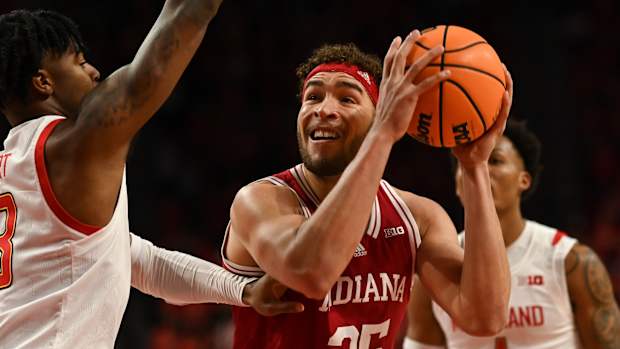 Race Thompson (25) looks to shoots as Maryland Terrapins guard Hakim Hart (13) defends.